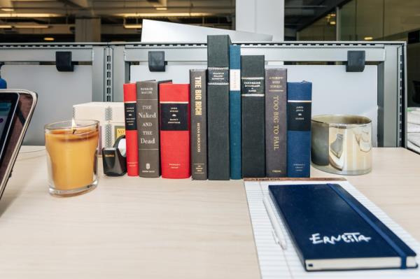 John Foley's desk at Ernesta in Manhattan, filled with a group of books, photographed on August 6, 2024 by Emmy Park.